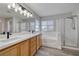 Bright bathroom with dual sinks, a soaking tub, a glass-enclosed shower, and a large mirror at 7836 Pinnochio Ave, Las Vegas, NV 89131