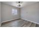 Bright bedroom with wood-look floors and a large window with venetian blinds at 7836 Pinnochio Ave, Las Vegas, NV 89131