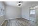 Neutral bedroom featuring wood-look floors, a window and mirrored closet doors at 7836 Pinnochio Ave, Las Vegas, NV 89131
