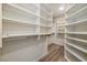 Walk-in closet featuring white built-in shelving, storage and wood floors at 7836 Pinnochio Ave, Las Vegas, NV 89131