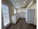 Open kitchen with white cabinets, laminate countertops, modern appliances, and wood-look flooring at 8009 Draco Cir # 201, Las Vegas, NV 89128