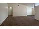 Spacious carpeted living room with neutral paint, a high ceiling, and an open doorway to another room at 8009 Draco Cir # 201, Las Vegas, NV 89128