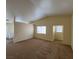 Inviting carpeted living room with vaulted ceiling, and an opening leading to a room with a door to the exterior at 8009 Draco Cir # 201, Las Vegas, NV 89128