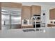View of kitchen island with sink, stainless steel refrigerator, built-in microwave, and coffee machine at 818 Calluna St, Las Vegas, NV 89138