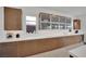 Kitchen showcases light wood cabinets and drawers with a long white countertop and frosted display cabinets above at 818 Calluna St, Las Vegas, NV 89138