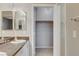 Bathroom with double sinks, granite countertop, and an open closet for storage at 1004 Country Skies Ave, Las Vegas, NV 89123