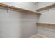 Spacious walk-in closet with wooden rod and shelving in neutral color scheme at 1004 Country Skies Ave, Las Vegas, NV 89123