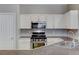 Well-equipped kitchen featuring stainless steel appliances, white cabinets, and stone countertops at 1004 Country Skies Ave, Las Vegas, NV 89123