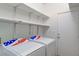 A laundry room with white appliances, shelves, and a door, offering convenient utility space at 1004 Country Skies Ave, Las Vegas, NV 89123