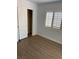 This bedroom features wood laminate flooring and a window with white shutters at 1066 Slate Crossing Ln # 3, Henderson, NV 89002