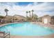 Community pool with lounge chairs, a covered seating area, and mature palm trees at 1066 Slate Crossing Ln # 3, Henderson, NV 89002