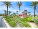 Attractive community entrance sign surrounded by lush landscaping and towering palm trees at 11593 Glowing Sunset Ln, Las Vegas, NV 89135