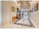 Long hallway with marble flooring, recessed lighting and framed art leading to the home's entry at 11593 Glowing Sunset Ln, Las Vegas, NV 89135