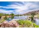 Picturesque pond framed by boulders and greenery, reflecting the clear sky and mountain views at 11593 Glowing Sunset Ln, Las Vegas, NV 89135