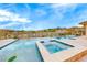 Inviting pool and spa featuring travertine trim and serene desert views at 11593 Glowing Sunset Ln, Las Vegas, NV 89135