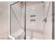 Modern walk-in shower with white tile, a built-in seat, and chrome fixtures at 11593 Glowing Sunset Ln, Las Vegas, NV 89135