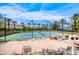 Well maintained tennis court with lighting and palm trees at 11593 Glowing Sunset Ln, Las Vegas, NV 89135