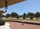 Expansive gravel patio with a decorative retaining wall and views of the open treed land beyond at 1211 Bourbon St, Pahrump, NV 89048