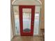 Close-up of the red entry door with decorative windows on either side at 1211 Bourbon St, Pahrump, NV 89048