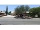 Charming single-story home with mature landscaping and a long driveway leading to an attached garage at 1211 Bourbon St, Pahrump, NV 89048