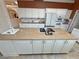 An open kitchen with white cabinets, granite countertops, a large island with sink and cooktop offers ample storage and food prep space at 1211 Bourbon St, Pahrump, NV 89048