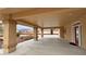 Large covered patio with pillars, desert landscaping, and red entry door at 1211 Bourbon St, Pahrump, NV 89048