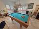 Pool table with overhead lighting fixture set up in a bright game room with plantation shutters at 1211 Bourbon St, Pahrump, NV 89048