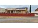 Back of house with solar panels, covered patio, brick wall and gate at 1211 Bourbon St, Pahrump, NV 89048