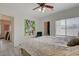 Main bedroom featuring a ceiling fan, large bed, and a brightly colored abstract artwork at 1401 Red Crest Ln # 201, Las Vegas, NV 89144