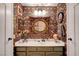 This half bath features colorful wallpaper, a stylish mirror, and a white porcelain sink at 1580 Rosita Dr, Las Vegas, NV 89123