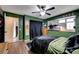 This bedroom features green walls, a ceiling fan, and a window with lots of natural light at 1580 Rosita Dr, Las Vegas, NV 89123