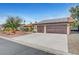 Exterior view of a home featuring a two-car garage, desert landscaping, solar panels, and a tile roof at 1580 Rosita Dr, Las Vegas, NV 89123