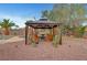 The backyard gazebo features outdoor seating, desert landscaping, and privacy landscaping at 1580 Rosita Dr, Las Vegas, NV 89123