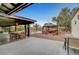 Covered patio with dining set overlooks a pergola, pool, and manicured backyard at 1580 Rosita Dr, Las Vegas, NV 89123