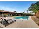 A backyard pool features lounge chairs, desert landscaping, and an outdoor living space at 1580 Rosita Dr, Las Vegas, NV 89123