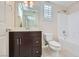 Bathroom featuring a dark wood vanity with a large mirror, white toilet and tub/shower combo at 2385 Orangeburg Pl, Henderson, NV 89044