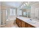 Bathroom featuring a large tub, dual sinks, wood cabinets, and a separate shower at 2385 Orangeburg Pl, Henderson, NV 89044