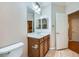 Bathroom vanity with wood cabinets, a sink, a mirror, and neutral tiling at 2385 Orangeburg Pl, Henderson, NV 89044
