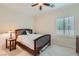 Cozy bedroom featuring a ceiling fan, light-colored walls, and a wooden bed frame at 2385 Orangeburg Pl, Henderson, NV 89044