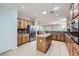 Open kitchen layout with wood cabinets, stainless steel appliances, granite counters, and a center island at 2385 Orangeburg Pl, Henderson, NV 89044