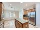 Bright kitchen showcasing a center island with granite countertop, stainless steel appliances, and tile floors at 2385 Orangeburg Pl, Henderson, NV 89044