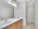 Bright bathroom with double sink vanity, large mirror, and glass-enclosed shower at 2580 Flare Star Dr, Henderson, NV 89044