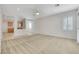 Well-lit living room showcasing neutral carpet, white walls, ceiling fan and view of kitchen at 2580 Flare Star Dr, Henderson, NV 89044