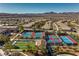 Aerial view of the blue and red tennis courts in a community near desert mountains at 2580 Flare Star Dr, Henderson, NV 89044