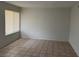 A bright living room with neutral walls and tiled flooring leading to a large bright window at 259 E Van Wagenen St # 259, Henderson, NV 89015