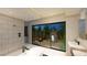 Modern bathroom featuring a soaking tub, walk-in shower, and a tranquil outdoor view at 2630 Juniper Branch St, Las Vegas, NV 89117