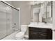 Cozy bathroom with glass-enclosed shower, white toilet, and a vanity with dark cabinets and sleek fixtures at 3012 Joy Meadow Ave, Henderson, NV 89074