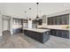 Modern kitchen with stainless steel appliances, a large island, pendant lighting, and gray wood floors at 3012 Joy Meadow Ave, Henderson, NV 89074