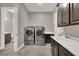 Well-equipped laundry room featuring stainless steel appliances and dark cabinetry at 3012 Joy Meadow Ave, Henderson, NV 89074