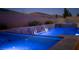 Modern in-ground pool and spa with waterfall features, brick surround, and accent lighting at 3012 Joy Meadow Ave, Henderson, NV 89074